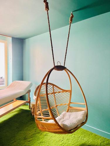 a hanging swing in a room with a bed at La suite Emois et Toi in Orléans