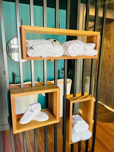 a room with three wooden shelves with towels at La suite Emois et Toi in Orléans