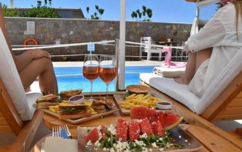 a table with a tray of food and glasses of wine at Koukounari Apartments in Skala