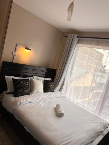 a bedroom with a bed with a large window at The cozy Cove in Nairobi