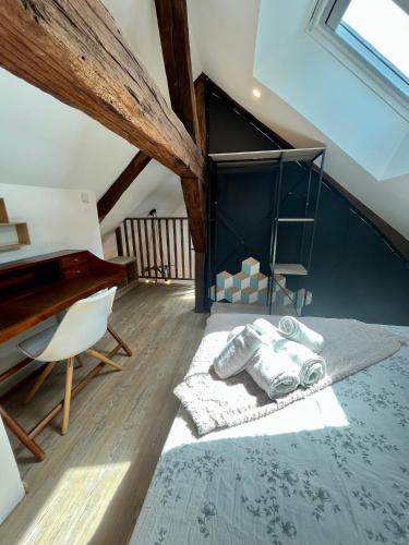 - une chambre mansardée avec un lit et un piano dans l'établissement Côté Renaissance - Hypercentre Blois, à Blois