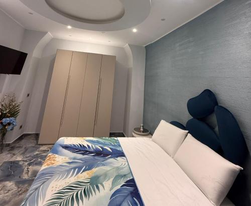 a bedroom with a large bed with a blue chair at Naomi Luxury Home 3 in Catania