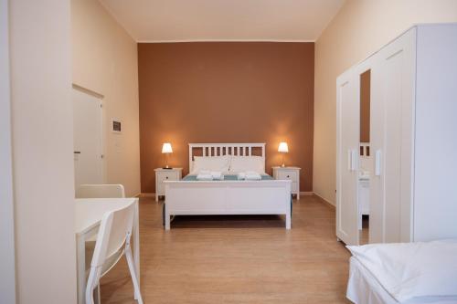 a bedroom with a white bed and two tables at Room Nabigi' - Centro Storico in Conversano