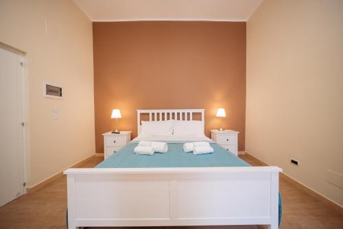 a bedroom with a white bed with two pillows at Room Nabigi' - Centro Storico in Conversano