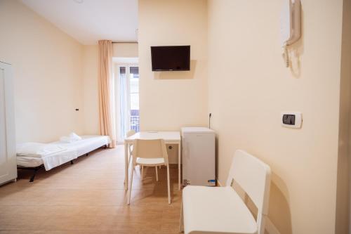 a room with a table and a room with beds at Room Nabigi' - Centro Storico in Conversano