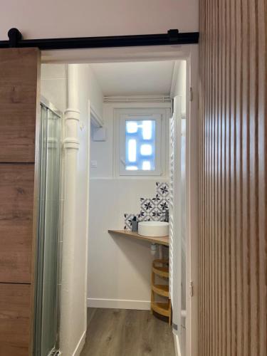 a bathroom with a glass shower and a window at Studio 48 Confort & Modernité Au cœur du Havre in Le Havre