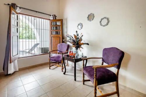 a room with two chairs and a table and a window at Casa Praxedis in Santiago