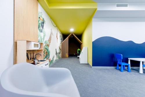 a room with a kitchen with a table and blue chairs at Resort Apartamenty Klifowa Rewal 97 in Rewal