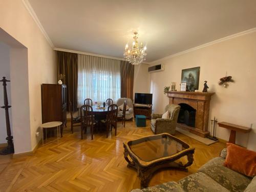 a living room with a fireplace and a dining room at Villa Visteria with terrace in Batumi