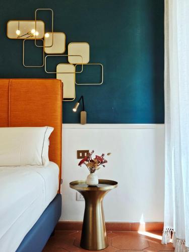 a bedroom with a bed and a table with flowers on it at SPIRIT OF FLORENCE Boutique Rooms in Florence