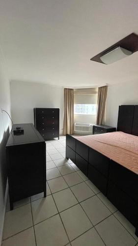Un dormitorio con una cama y un escritorio y una ventana. en Mikano Properties, en Jayuya