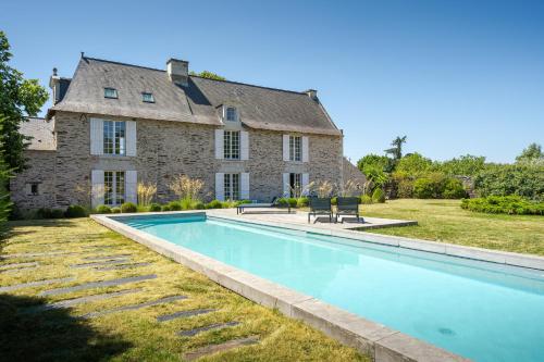 une grande maison en pierre avec une piscine en face de celle-ci dans l'établissement Le Logis de Saint Jean, à Les Garennes sur Loire