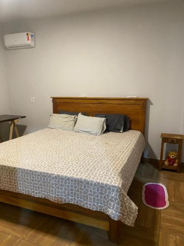 a bedroom with a bed with a wooden headboard at Rancho Royer in Araguari