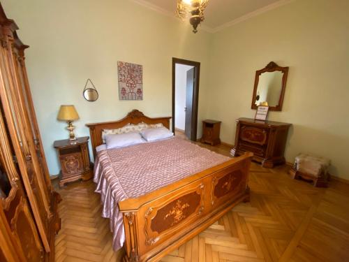 a bedroom with a wooden bed and two night stands at Villa Visteria with terrace in Batumi