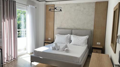 a bedroom with a white bed with towels on it at Hotel DEMOLI in Pogradec