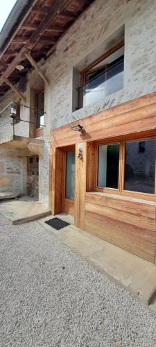a wooden garage door on a stone building at Gîte Le Verger in Traize