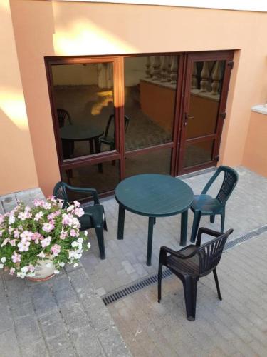a patio with a table and chairs and a pot of flowers at Little Amber Apartments in Klaipėda