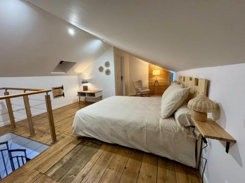 a bedroom with a large bed and a wooden floor at L'atelier du Vannier in Fayl-Billot
