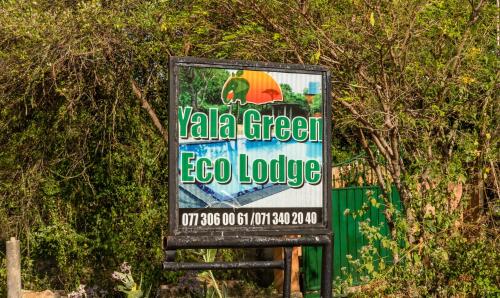a sign for a localeco lodge in front of a bush at Yala Green Eco Lodge in Kirinda