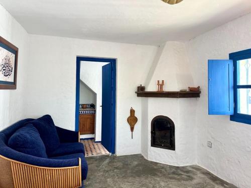 a living room with a blue chair and a fireplace at La Casa de las Higueras Dar Karmus Tetouan in Tetouan