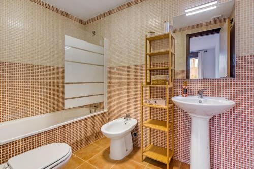 a bathroom with a sink and a toilet and a mirror at Oasis in Los Collados - 2BR - Pool & Garden in Águilas