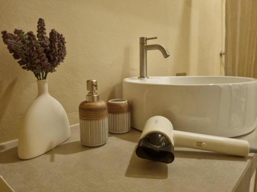 una encimera con lavabo y flores. en Hidden Gem Cozy House, en Wok Tum