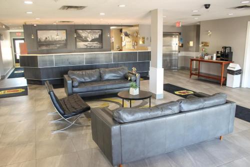 a lobby with two leather couches and a table at Super 8 by Wyndham Edmonton South in Edmonton