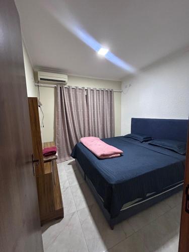 a bedroom with a blue bed and a window at Furnished house in Fazenda Rio Grande