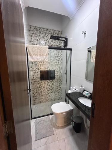 a bathroom with a shower and a toilet and a sink at Furnished house in Fazenda Rio Grande