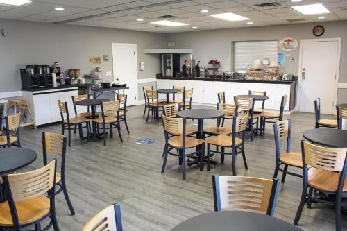 a dining room with tables and chairs and a counter at Super 8 by Wyndham Edmonton South in Edmonton