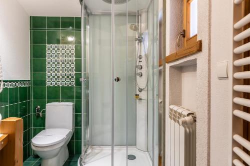 a green tiled bathroom with a toilet and a shower at Hotel Bambi Boutique in Zakopane