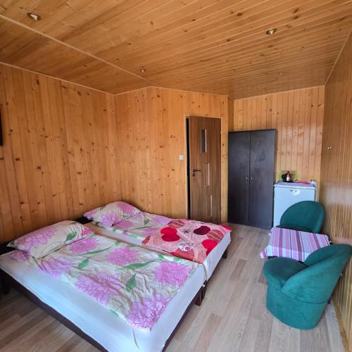 a bedroom with a bed and two chairs in it at Domki letniskowe SOKÓŁ in Okuninka