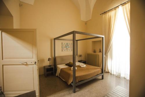 a bedroom with a canopy bed and a window at 4 Balconi rooms-Boutique B&B in Lecce