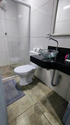 a bathroom with a white toilet and a sink at Hotel Iracemar - Econômico in Guarujá