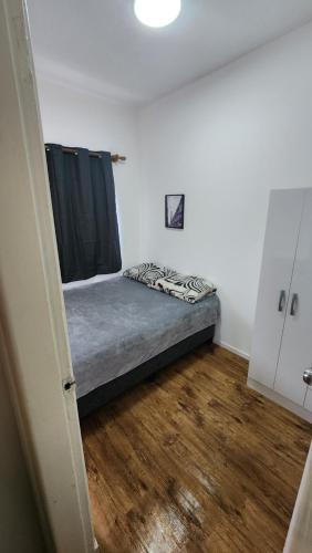 una cama en una habitación con suelo de madera en Casa en Tres Cruses, en Montevideo