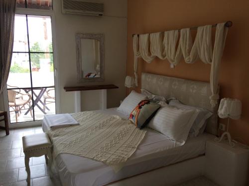 a bedroom with a bed with a large window at Studios Eliza in Livadion