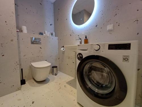 a washing machine in a bathroom with a toilet at Luise LuXe Suites in Tallinn