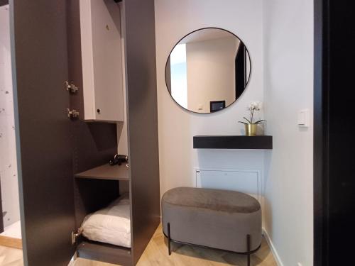 a small bathroom with a mirror and a stool at Luise LuXe Suites in Tallinn