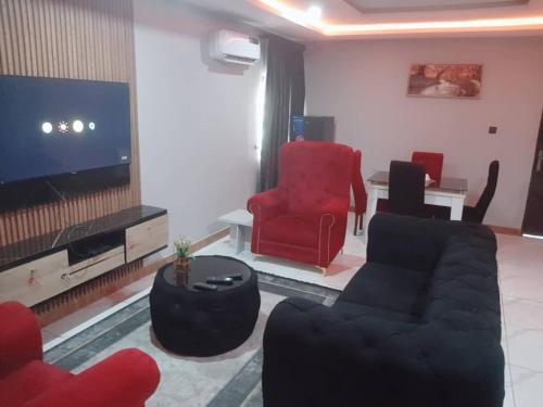 a living room with a couch and two chairs and a television at Prestige Haven in Lagos Island