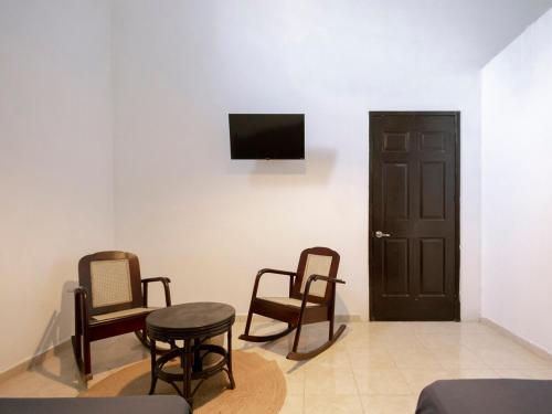 a room with three chairs and a table and a television at Casa Kaity 1 block from downtown in Valladolid