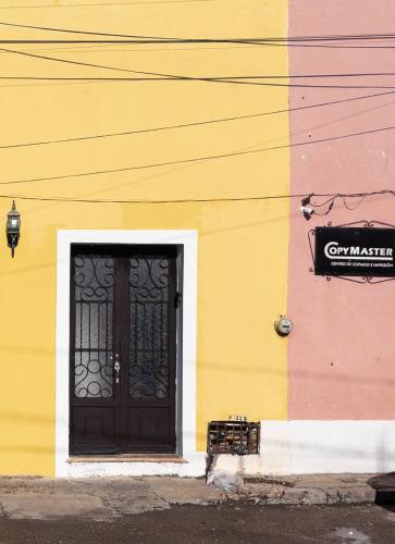 a building with a black door and a sign on it at Casa Kaity 1 block from downtown in Valladolid