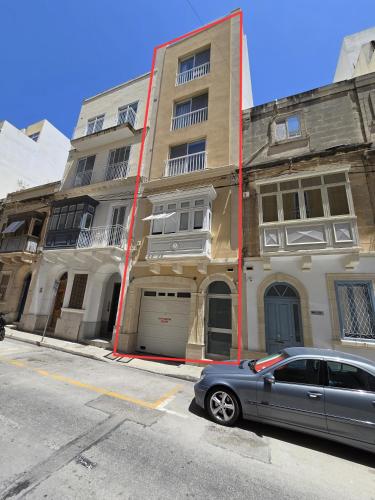 a gray car parked in front of a building at Cozy 2 Bedroom Steps to Seafront in Il-Gżira