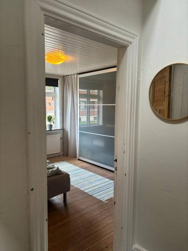 a hallway leading to a living room with a mirror at Private apartment near Billund in Grindsted