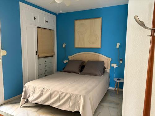 a bedroom with blue walls and a bed in a room at The Bajondillo terrace in Torremolinos