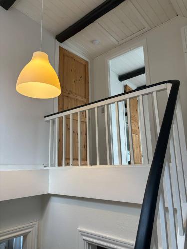 a stair case with a yellow light and a stair railing at Private apartment near Billund in Grindsted