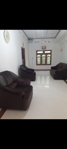 a living room with two couches and two windows at Sri Kumaran in Jaffna