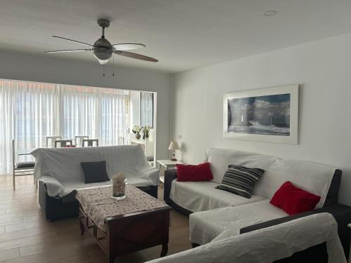 ein Wohnzimmer mit weißen Möbeln und einem Deckenventilator in der Unterkunft 150m2 Con vistas al Mar y al Castillo de Cullera in Cullera