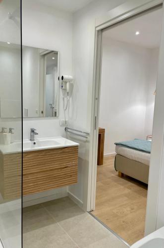 a bathroom with a sink and a shower and a bed at Elis rooms & suite in Olbia