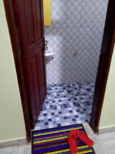a bathroom with a door and a rug on the floor at CTS Suites in Kampala