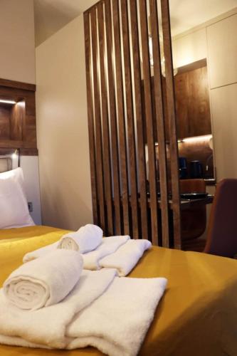 a pile of towels sitting on top of a bed at Superior Petit Studio in Mytilini